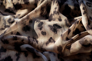 Fabric with a wild animal pattern leopard, abstract background with sunlight