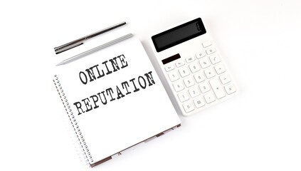Notepad with text ONLINE REPUTATION with calculator and pen. White background. Business