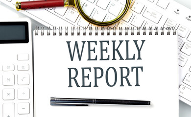 WEEKLY REPORT . Text on notepad with calculator and keyboard,business concept