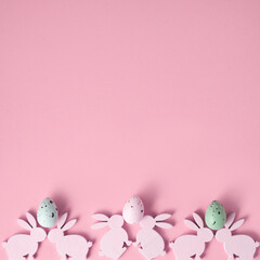 Obraz na płótnie Canvas Easter composition made with Easter bunnies and eggs on bright pink background. Minimal creative holiday concept.
