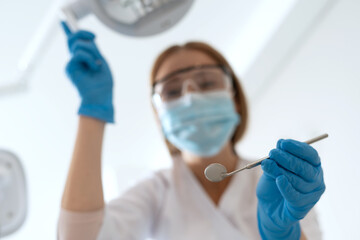 Stomatologist with dental instruments looking at camera