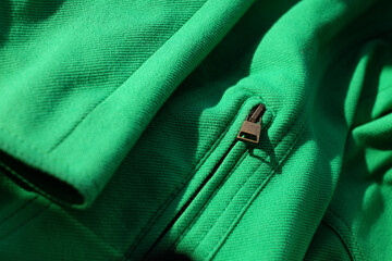 Details of green jacket, close-up, fashion abstract background with sunlight