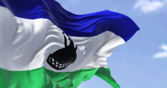 Detail of the national flag of Lesotho waving in the wind on a clear day