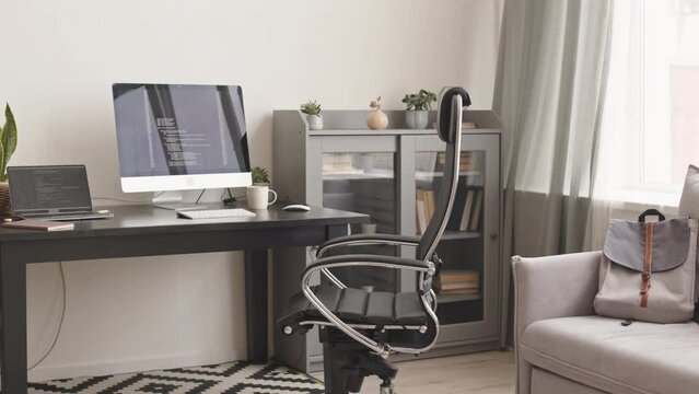 No people PAN slowmo of modern programmer workplace at home with running program codes on laptop and pc computer at desk