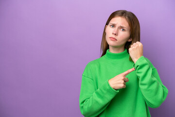 Young English woman isolated on purple background making the gesture of being late