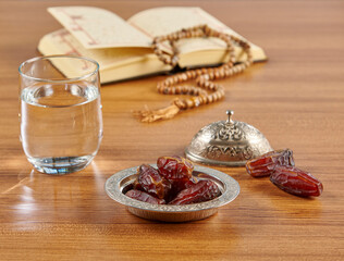 Ramadan date water and turkish style zinc silver plate, rosary style on the wooden table.