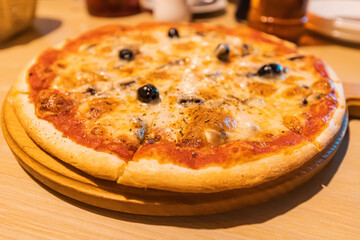 Pizza on a stand on the table in a restaurant or fast food Italian cafe