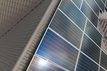 Obraz premium Aerial view building roof with rows of blue solar photovoltaic panels for producing clean ecological electric energy. Renewable electricity with zero emission concept