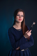 Obraz premium a series of photos of a young girl model - makeup artist with a brush for makeup in her hands, on a black isolated background