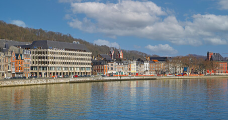 Fototapeta na wymiar Liege, Belgium - March 5. 2022: View over river maas on historical waterfront houses against blue winter sky