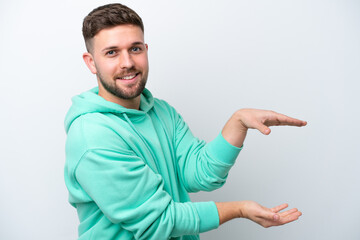 Young caucasian man isolated on white background holding copyspace to insert an ad