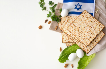 Layout of  Traditional Matzah prepared for Passover with egg, flag, green salad and parsley on white background. top view. Spring Holiday of Jewish people. Fasting time. Space for text.