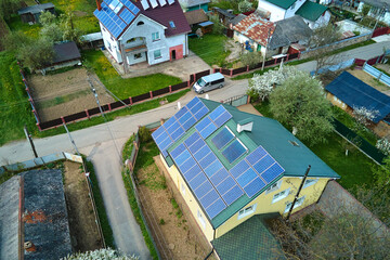 Residential house with rooftop covered with solar photovoltaic panels for producing of clean ecological electrical energy in suburban rural area. Concept of autonomous home