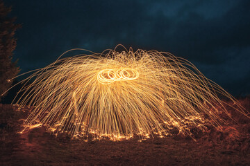 Burning steel wool spinned. Showers of glowing sparks from spinning steel wool