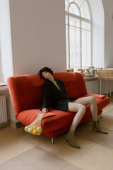 Stylish and cute girl in fashionable clothes in a minimalist interior