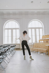 Fototapeta premium Stylish and cute girl in fashionable clothes in a minimalist interior