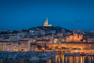 The Old Port and Basilica of Notre Dame de la Garde at dusk in Marseille, France