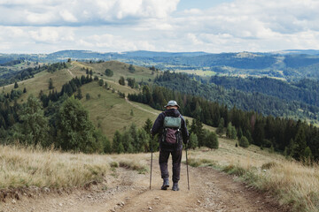 Fototapeta premium Hiker man with backpack and trekking sticks