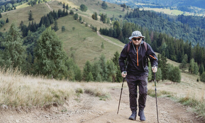 Fototapeta na wymiar Hiker man with backpack and trekking sticks