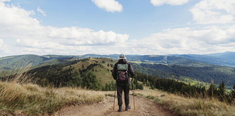 Fototapeta na wymiar Hiker man with backpack and trekking sticks