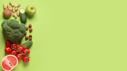 Different vegetables, fruits and nuts on green background