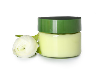 Jar of cosmetic product and ranunculus flower on white background