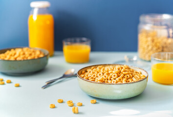 Breakfast concept with cold cereals and orange juice on blue background