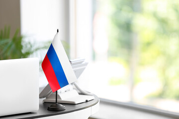 Russian flag and laptop on table in office