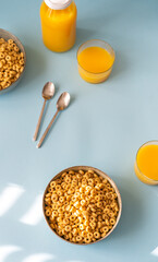 Breakfast concept with cold cereals and orange juice on blue background