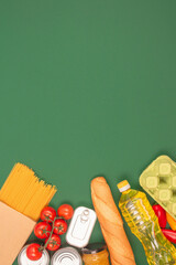 Vertical image with groceries, food donations on green background with copy space - pasta,...