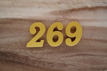 Golden Arabic numerals on a real brown and white wooden floor number 269
