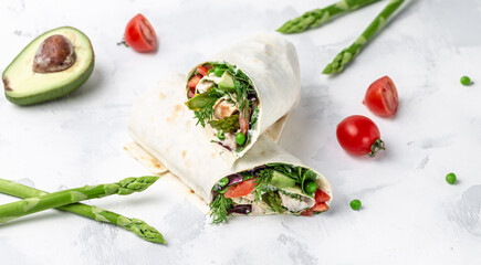 tortilla wraps chicken and vegetables asparagus, avocado, tomatoes, peas, cheese on cutting board. Food recipe background. Close up