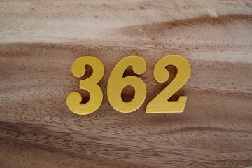 Golden Arabic numerals on a real brown and white wooden floor number 362