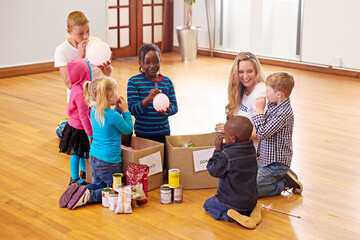 Putting smiles on their little faces. Shot of a volunteer working with little children.