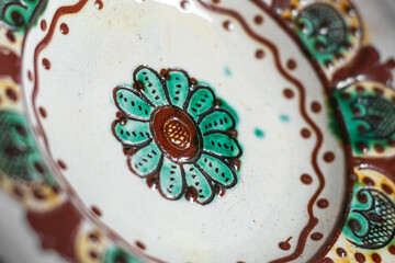 Close-up of a traditional authentical Ukrainian glazed clay plate with an ornament.