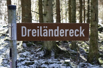 Sign 'Dreil&auml;ndereck' (border triangle Hessia, Rhineland-Palatinate, North Rhine-Westphalia) with water drops, winter forest (horizontal), Rabenscheid, Hessia, Germany