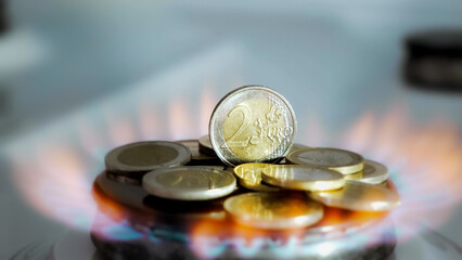 Concept of gas crisis. 2 Euro coins is burning on a kitchen stove burner and fall when the gas end. High prices of natural resources. Fire flame. Utility debt. Energy war. Saving home budget. Finance