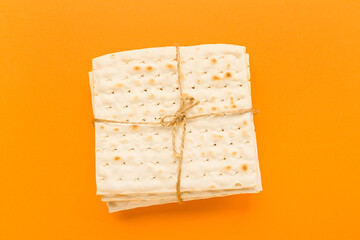 Jewish flatbread matza for Passover on orange background