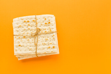 Jewish flatbread matza for Passover on orange background