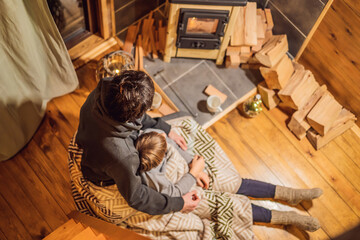 Dad and son spend time by the fireplace in Glamping. Rest in the mountains in Glamping. Cozy fireplace in a mountain house