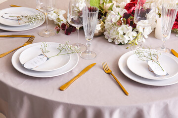 Stylish table setting with wedding invitations and gypsophila flowers
