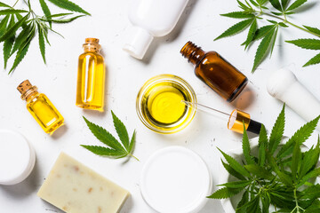Cannabis cosmetic at white. Cannabis oil, cream, soap and fresh green leaves at white background....