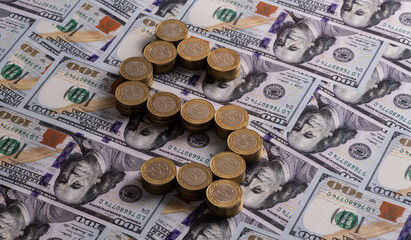 A coin of 100 Kazakhstani tenge, folded in the form of a dollar sign and a bill of 100 US dollars