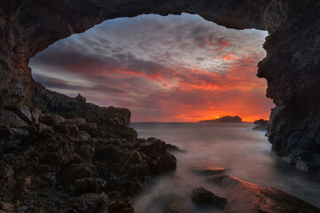 Sa Figuera Borda Cave at sunset with red sky , Ibiza  - obrazy, fototapety, plakaty