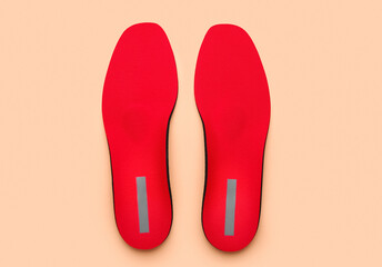 Red orthopedic insoles on color background