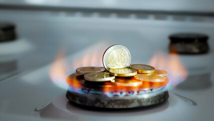 Concept of gas crisis. 2 Euro coins is burning on a kitchen stove burner and fall when the gas end. High prices of natural resources. Fire flame. Utility debt. Energy war. Saving home budget. Finance