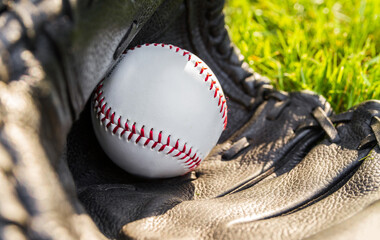 Baseball glove and ball. Sport equipment in grass.