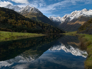 Premières neiges au dessus du lac d'Estaing dans les Pyrénées. Reflet des montagnes dans le lac.