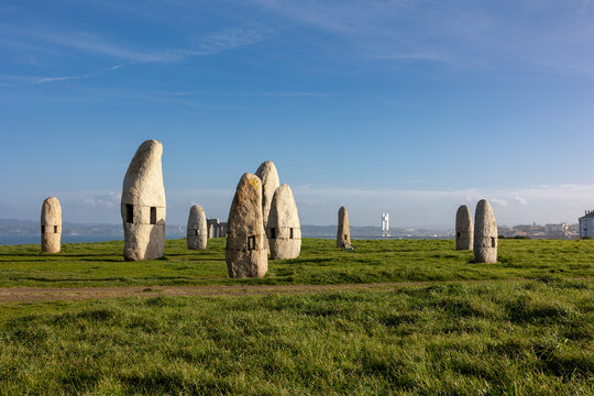 Stone historical sculptures, a green park, a blue sky.