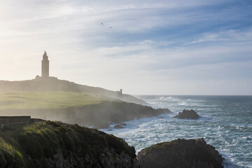 Fototapeta na wymiar An ancient lighthouse in the fog on the ocean shore